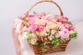 Flowers arrangement with various of colors in wicker basket on pink table. beautiful spring bouquet. bright room, white Royalty Free Stock Photo