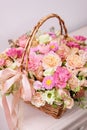 Flowers arrangement with various of colors in wicker basket on pink table. beautiful spring bouquet. bright room, white Royalty Free Stock Photo