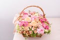 Flowers arrangement with various of colors in wicker basket on pink table. beautiful spring bouquet. bright room, white Royalty Free Stock Photo