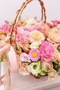 Flowers arrangement with various of colors in wicker basket on pink table. beautiful spring bouquet. bright room, white Royalty Free Stock Photo