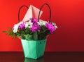 Beautiful spring bouquet of flowers in basket with love envelop on table, gift for women`s day, mother`s day, 8 march, 9 may on