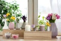 Beautiful spring flowers with burning candles on window sill Royalty Free Stock Photo