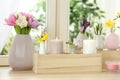 Beautiful spring flowers with burning candles on window sill Royalty Free Stock Photo