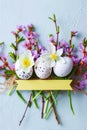 Beautiful spring flowers, Easter eggs and paper sheet for greeting text on light background