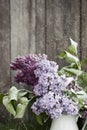 Beautiful spring flowers. purple lilac in white vase on wood old background Royalty Free Stock Photo