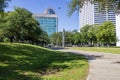 a beautiful spring landscape at Duncan Plaza with a footpath, lush green trees, grass and plants, a statue, the City Hall Building