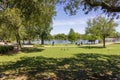 A beautiful spring landscape at New Orleans City Park with people, lush green trees, grass and plants, a lake, birds and blue sky