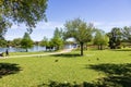 A beautiful spring landscape at New Orleans City Park with people, lush green trees, grass and plants, a lake, birds and blue sky