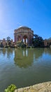 A beautiful spring landscape at Palace of Fine Arts with a lake, lush green trees and plants and beautiful buildings with blue sky
