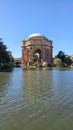 A beautiful spring landscape at Palace of Fine Arts with a lake, lush green trees and plants and beautiful buildings with blue sky