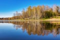 Beautiful spring landscape. Reflection of the blue cloudless sky and trees in the calm water of a forest lake Royalty Free Stock Photo