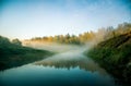 A beautiful spring landscape of a river valley with morning mist. Springtime scenery of a river flowing through the forest. Royalty Free Stock Photo