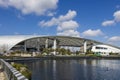 A beautiful spring landscape at SoFi Stadium with lush green palm trees and plants, a lake with birds swimming, blue sky Royalty Free Stock Photo