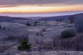 Beautiful spring landscape: sunset, trees, forest, mountains, hills, fields, meadows and sky. Gorgeous, red sky with heavy clouds Royalty Free Stock Photo