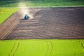 Beautiful spring landscape with working tractor on green and brown field in South Moravia, Czech Republic. Agriculture concept Royalty Free Stock Photo