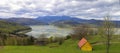 Beautiful spring panorama of Izvorul Muntelui Lake with yellow house in front and Ceahlau mountain in background. Royalty Free Stock Photo