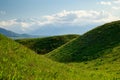 Beautiful spring and summer landscape. Lush green hills, high mountains. Spring blooming herbs. Mountain wild tulips. Blue sky and