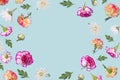 Beautiful spring or summer layout with different flying flowers and leaves on pastel blue background, trendy floral frame