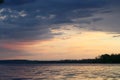 Spring sunset on the river with a beatiful sky in pastel colors and silhoettes of trees.