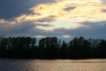 Spring sunset on the river with a beatiful sky in pastel colors and silhoettes of trees.