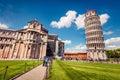 Beautiful spring view of famous Leaning Tower in Pisa. Sunny morning scene with hundreds of tourists in Piazza dei Miracoli