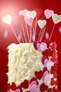 Valentines Day party table with showstopper hearts cake with lens flare. Royalty Free Stock Photo