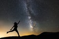 Beautiful starry night, female silhouette jumping on the milky way background. Night landscape. with milky way galaxy.