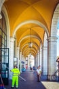 Beautiful station in Pisa with white pillars and yellow arches, with working cleaners and tourists, Pisa, Italy Royalty Free Stock Photo