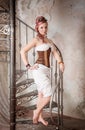Beautiful steampunk woman with trousers on the stairway