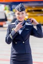 Beautiful stewardess dressed in official dark blue uniform of Aeroflot Airlines on airfield. Passenger jet aircraft on background.