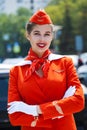 Young stewardess dressed in official red uniform of Airlines