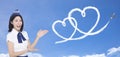 Beautiful stewardess showing the love and honeymoon travel concept on blue background