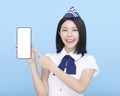 Beautiful stewardess showing the mobile phone with blank screen on blue background Royalty Free Stock Photo
