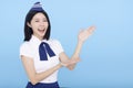 Beautiful stewardess showing something on blue background Royalty Free Stock Photo