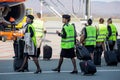 Beautiful stewardesses dressed in official dark blue uniform of Aeroflot Airlines and reflective vests go to plane on airfield.