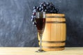 Beautiful still life with glass of red wine against background of oak wine barrel with red wine Royalty Free Stock Photo