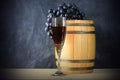 Beautiful still life with glass of red wine against background of oak wine barrel with red wine Royalty Free Stock Photo