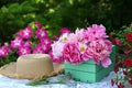 Beautiful still life with peony flowers, vintage cup and hat on the table. Royalty Free Stock Photo