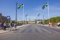 Beautiful Stockholm cityscape view with pedestrians crossing a central Stockholm road with Swedish flags for National Day. Royalty Free Stock Photo