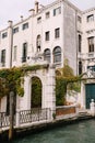 Beautiful stone arched entrance to the building, a green door and classic Venetian windows. Details of building facades Royalty Free Stock Photo