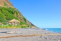 Beautiful stone beach in Madalena do Mar, Madeira, Portugal photographed in the late summer on a sunny day. Hill with banana Royalty Free Stock Photo