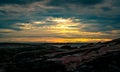 Beautiful stone beach in the morning with golden sunrise sky. Peaceful and tranquil scene. Landscape of calm sea in the morning. Royalty Free Stock Photo