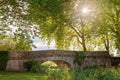 Beautiful stone bridge over a small pond with trees behind on a Royalty Free Stock Photo