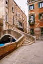 A beautiful stone bridge with a staircase across the Venetian Canal on the streets of Venice, in Italy. The facades of Royalty Free Stock Photo