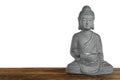 Beautiful stone Buddha sculpture on wooden table against grey background. Space for text