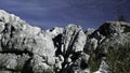 Beautiful stone cliffs. Creative. Large mountain ranges standing above a blue sunny sky next to tall reeds . Royalty Free Stock Photo