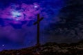 A beautiful stone cross on a mountain with a cosmic sky