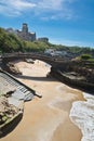 Beautiful stone walking footbridge over sandy beach in touristic destination surf spot with turquoise ocean and waves in biarritz