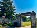 Beautiful stone wall fence with majestic archway over sidewalk