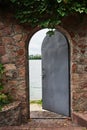 In the beautiful stone wall the iron door is ajar Royalty Free Stock Photo